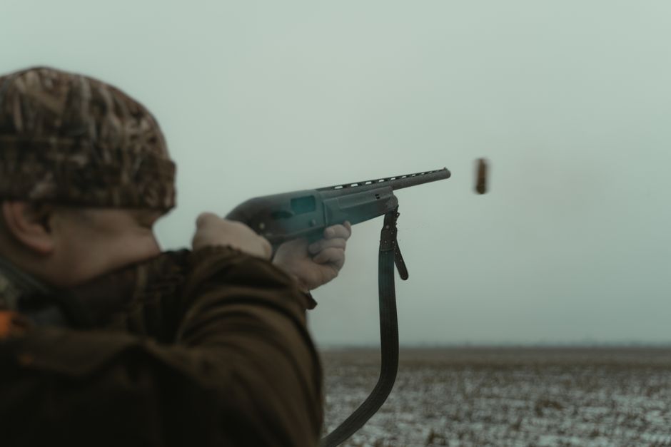 Hunter with rifle practicing marksmanship in outdoor shooting sports setting